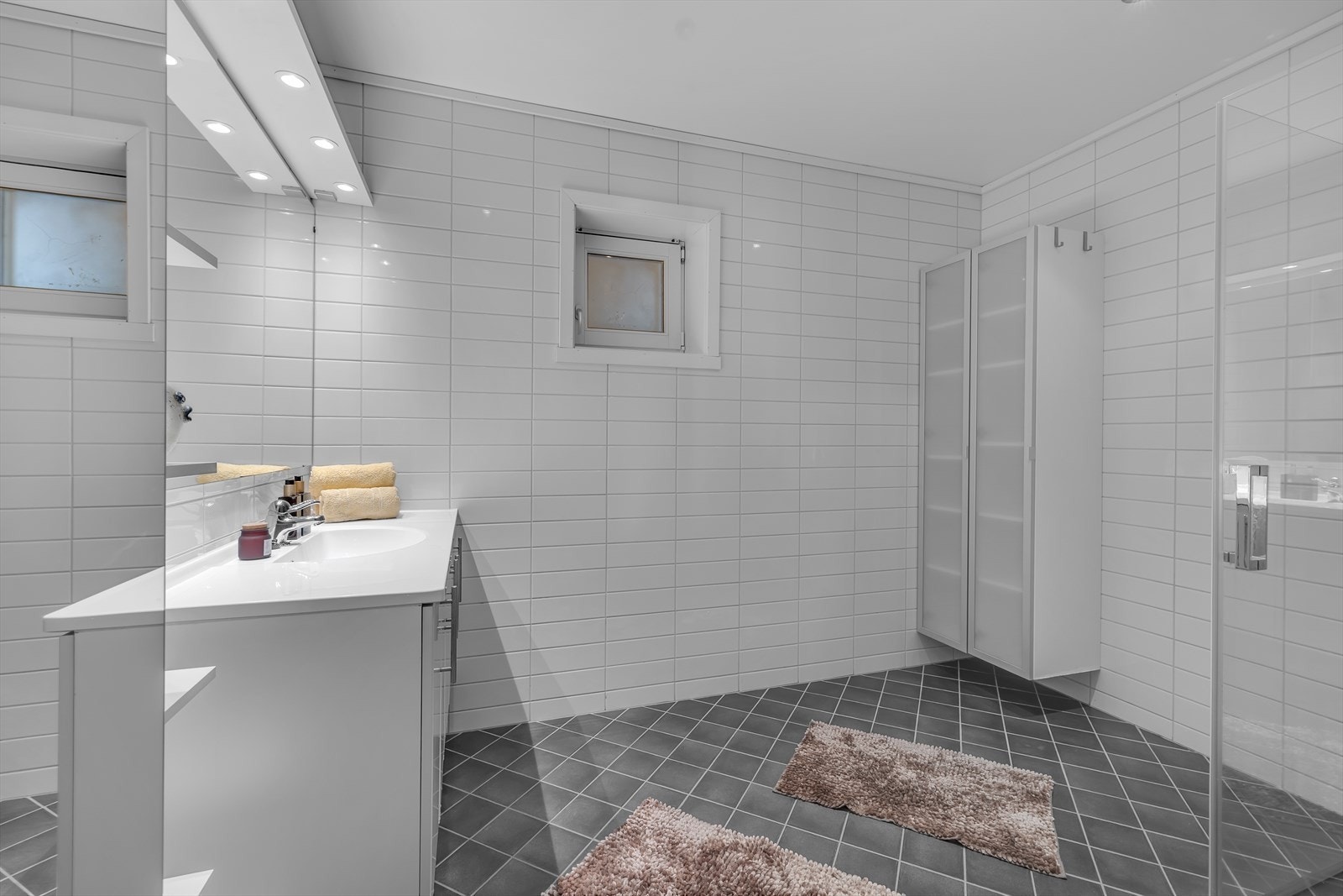 Romslig og fint bad, flislagt og med gulvvarme. Innslagbare dusjdører. Galleribilde