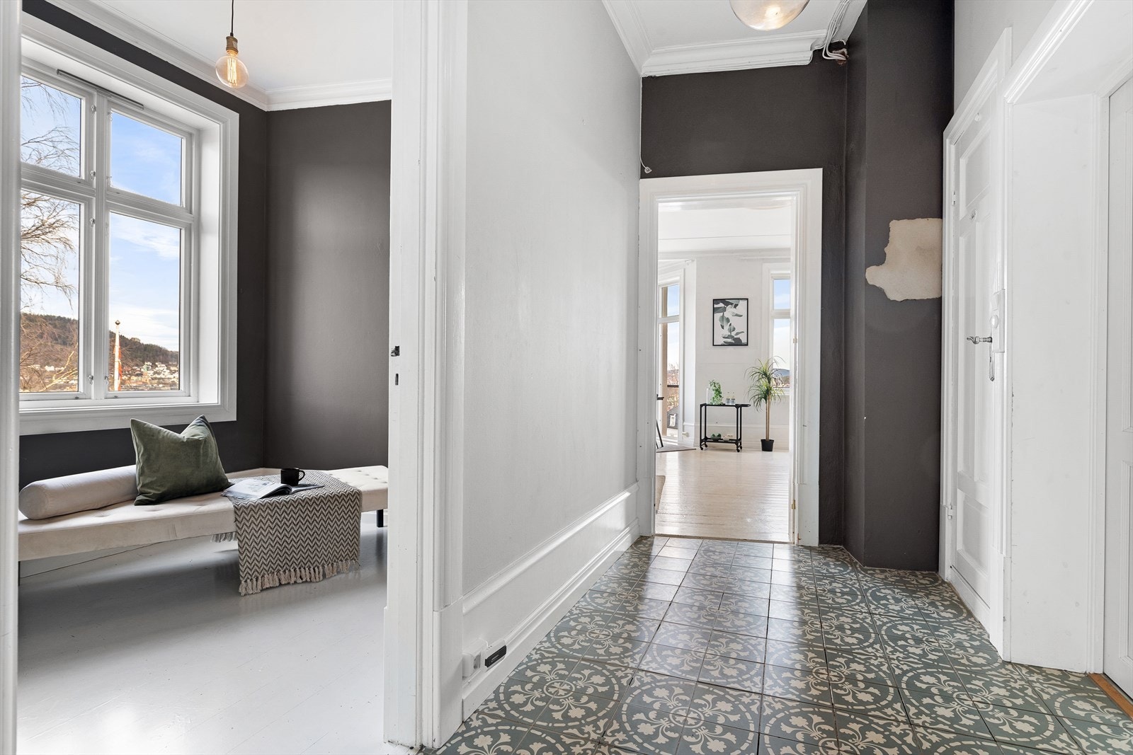 Romslig entré med klassiske fliser ønsker deg velkommen inn - legg merke til de klassiske detaljene med brede lister Galleribilde