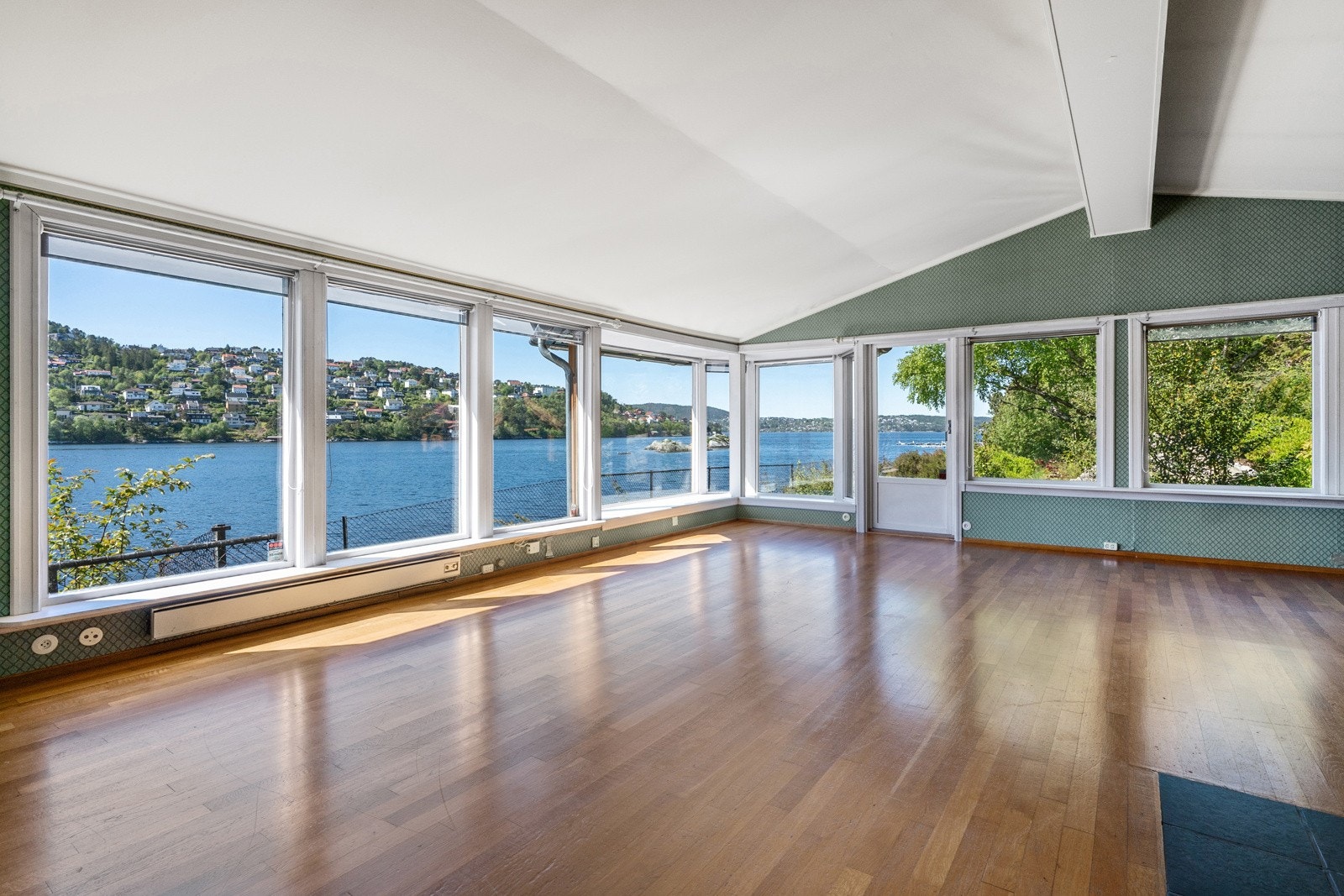 Stuen har store lysflater og utgang til hagen Galleribilde