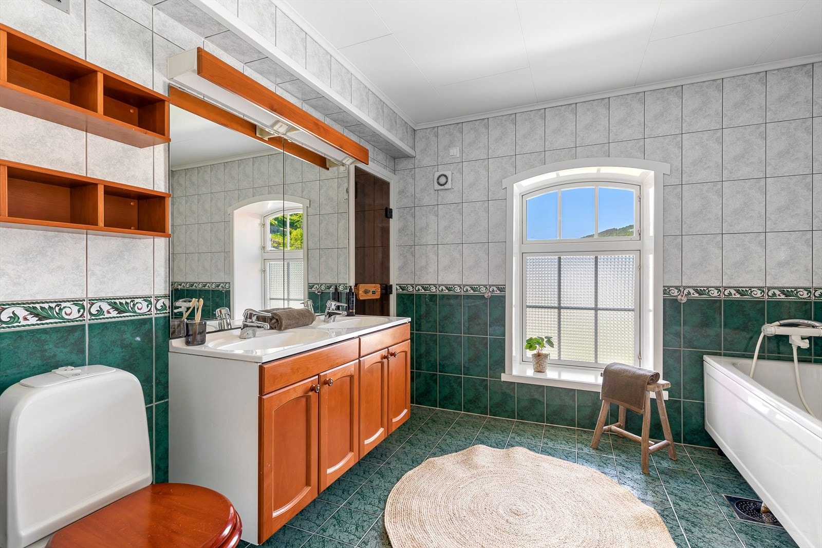 Heilflisa bad med varmekablar i golv. Rommet inneheld badekar, servant med innreiing, toalett... Galleribilde