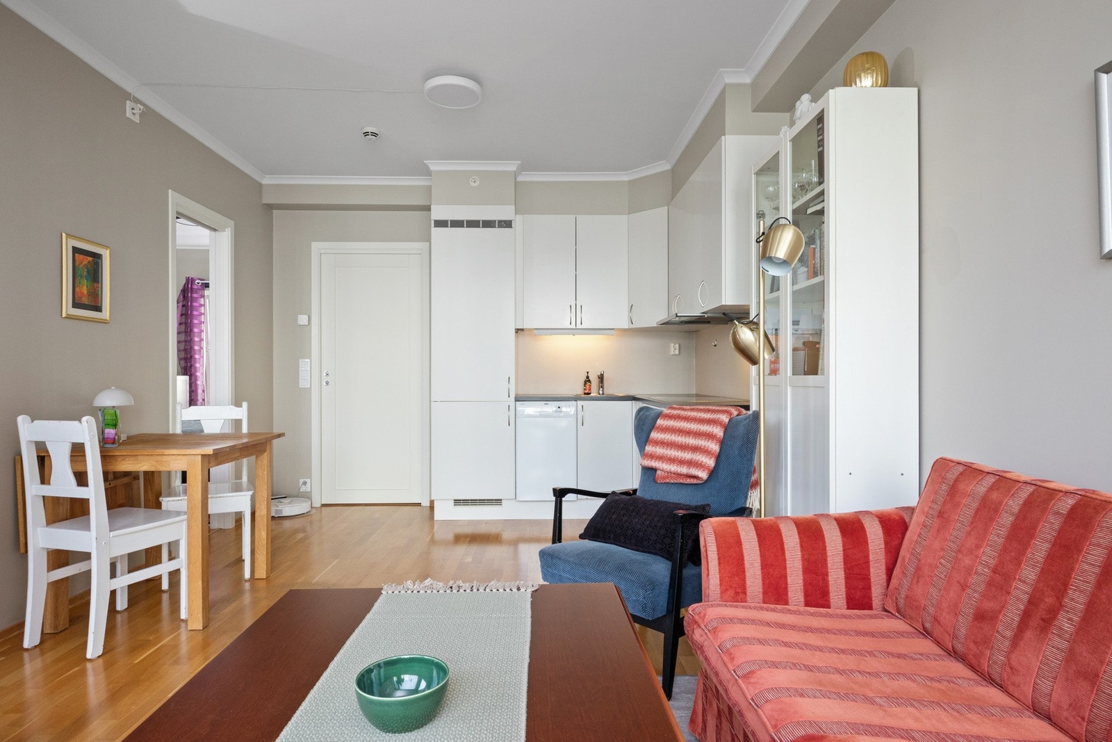 Kjøkkeninnredningen har hvite, glatte fronter, laminert benkeplate og nedfelt oppvaskkum. Galleribilde