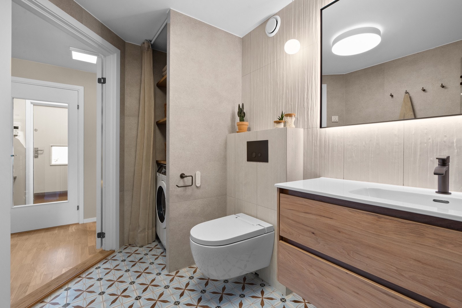 Det er varmekabler i gulv, vegghengt toalett med innebygget sisterne og dusjhørne med glassdører. Galleribilde