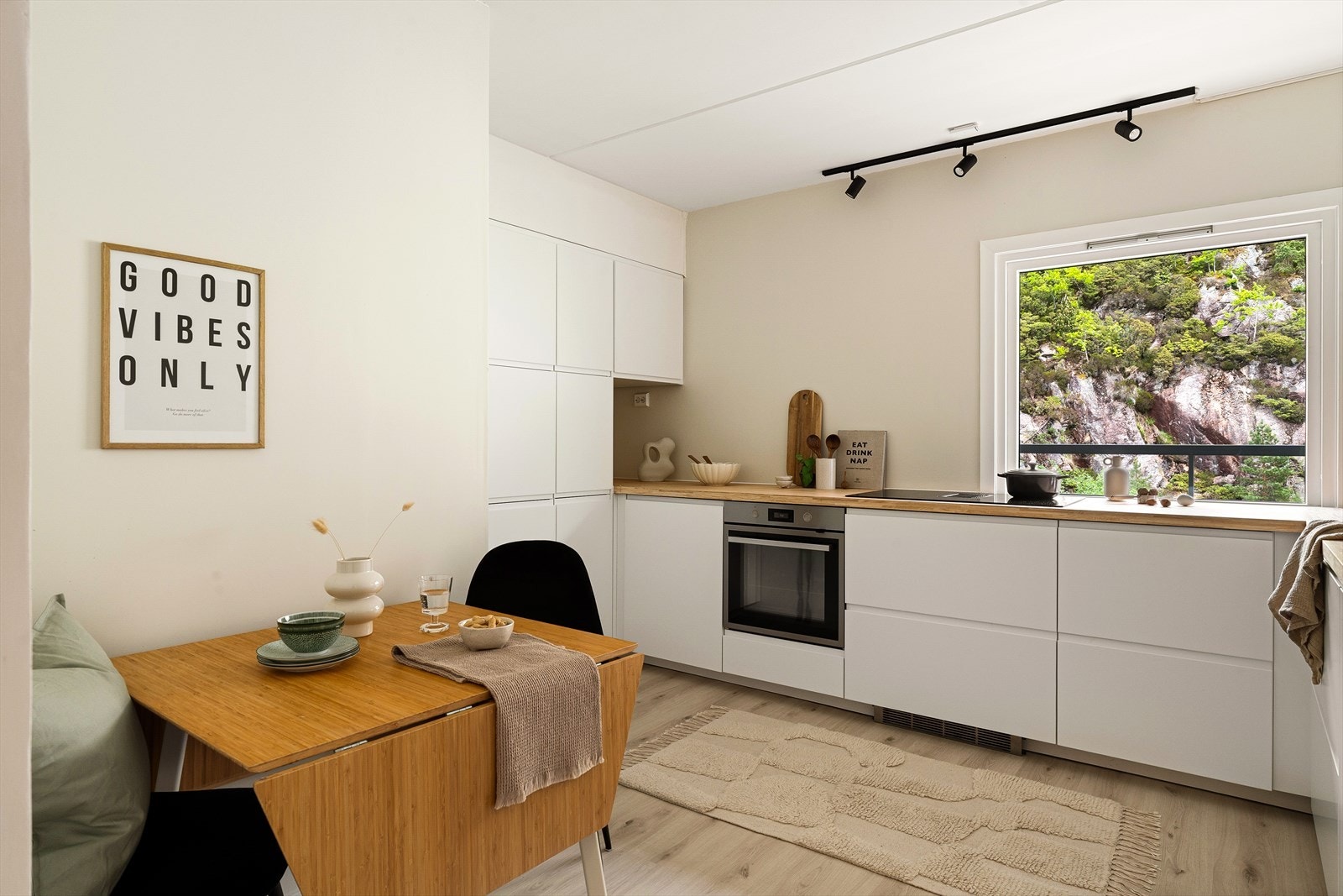 Stilfullt kjøkken fra IKEA nytt i 2024 med hvite slette fronter, integrerte håndtak og laminat benkeplate. Galleribilde