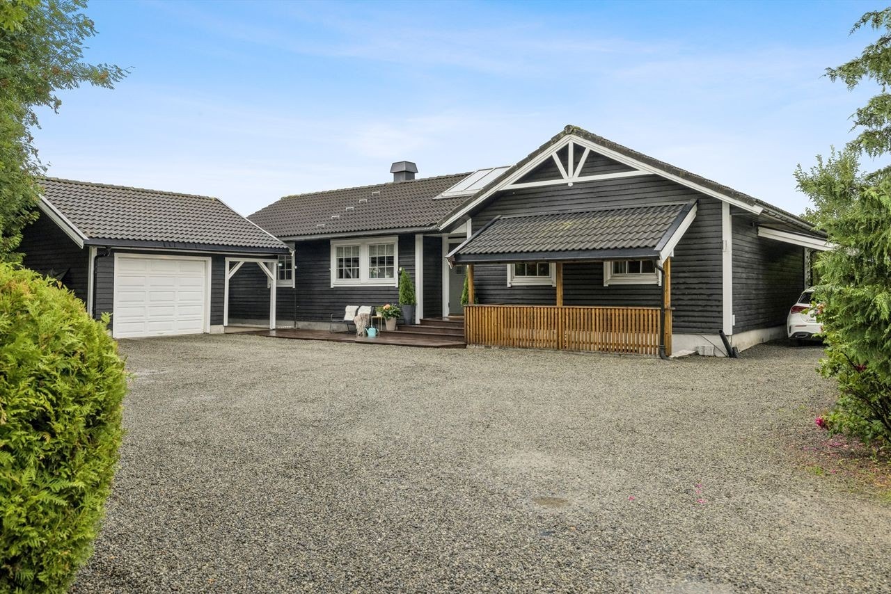 Romslig gårdsplass med garasje og carport. Galleribilde