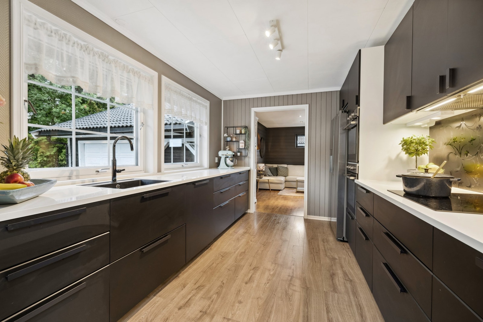 Praktisk og delikat innredet med mye skap og benkeplass. Integrerte hvitevarer. Galleribilde