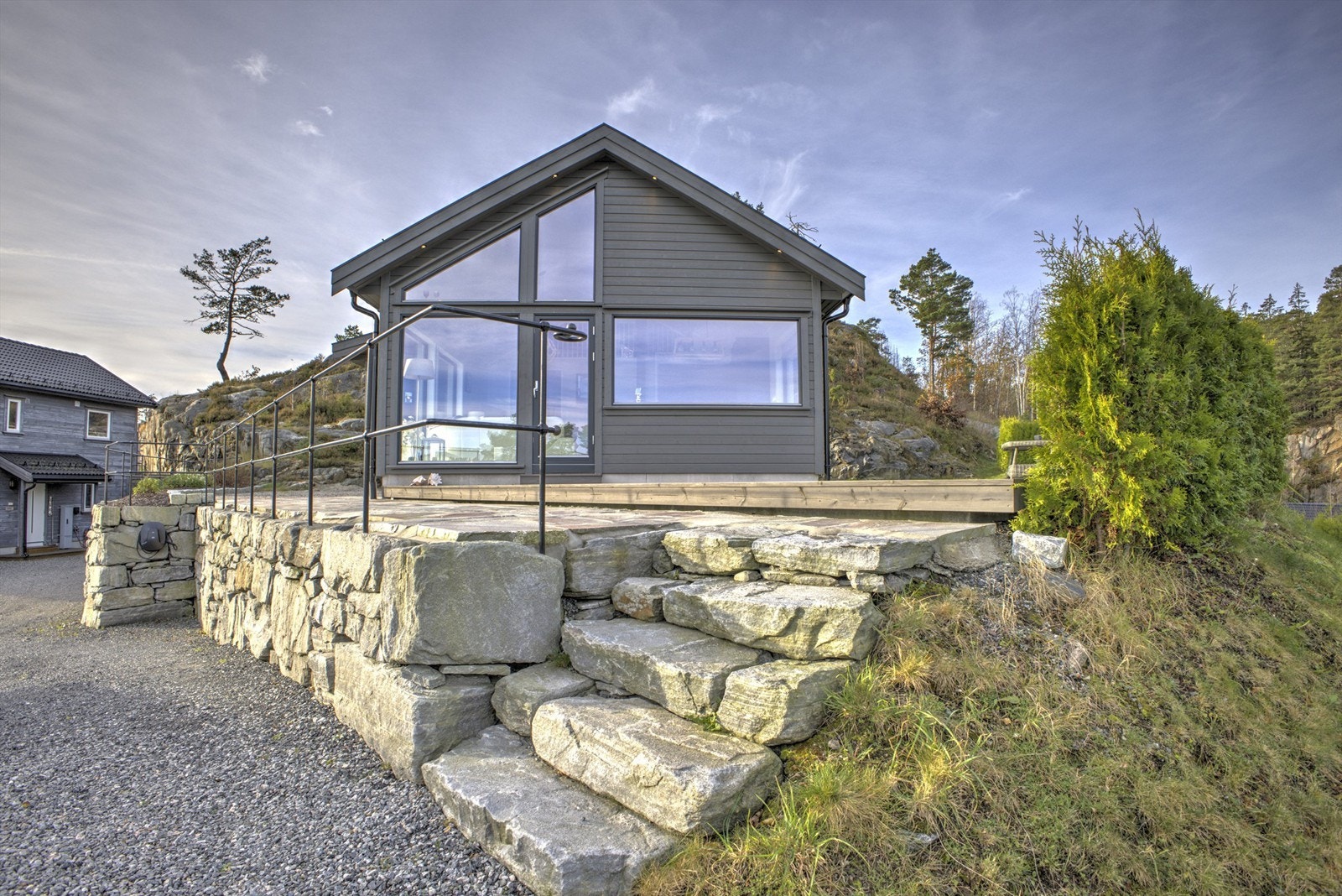 Flott steinmur, smijernsrekkverk og usjenert hage - Det er montert elbillader
som medfølger salget Galleribilde