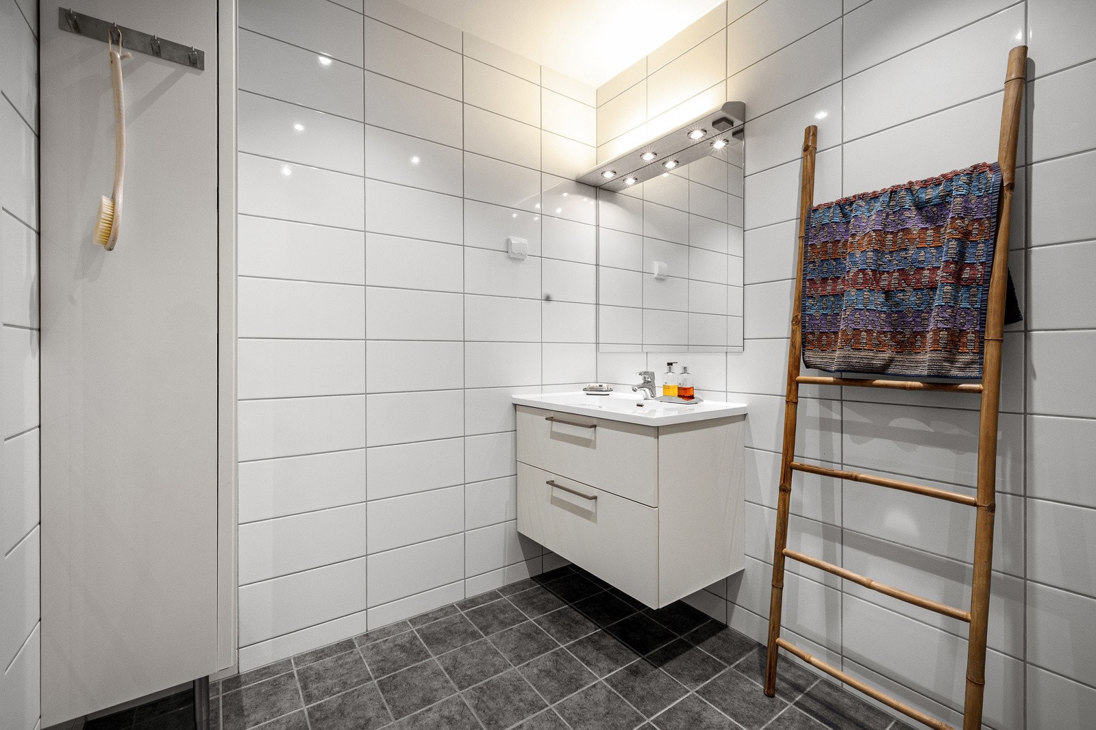 Badet er helfliset med lyse tidløse fliser på veggene og mørke fliser på gulvet. Galleribilde
