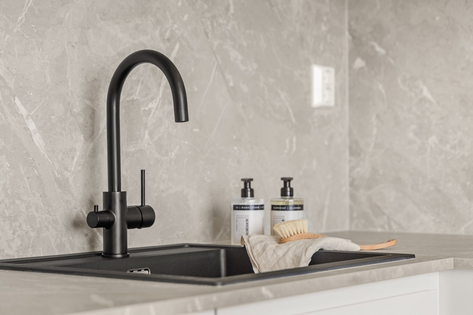 Lekre detaljer med sort armatur og vask Galleribilde