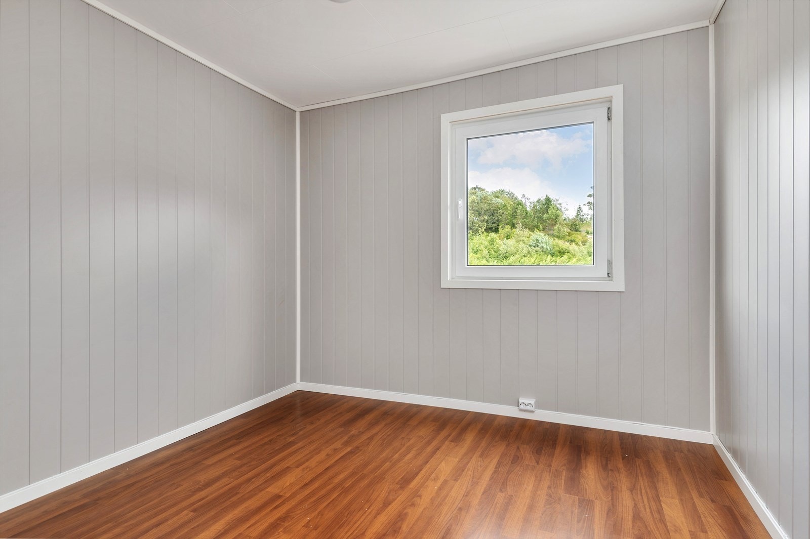 Flott soverom på 8 m² som har laminat på gulv og panelplater på vegg. Vender ut mot et rolig område. Galleribilde