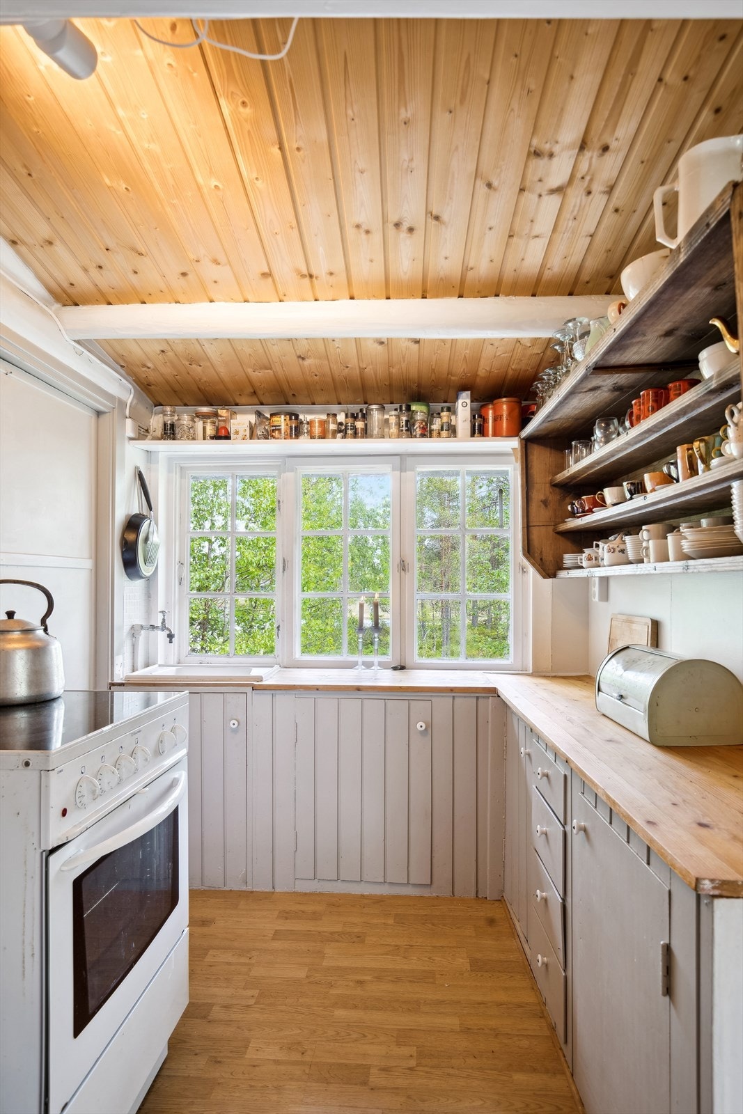 Det er frittstående komfyr med komfyrvakt på vegg og frittstående kjøleskap med fryser Galleribilde