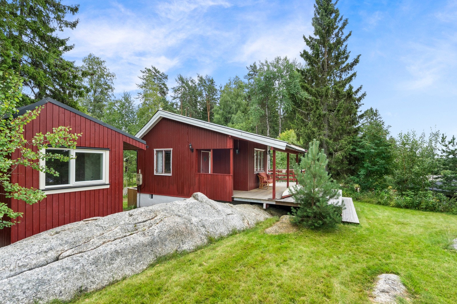 Tomten er pent opparbeidet med plen, fjell og diverse trær som skjermer tomten for innsyn. Galleribilde