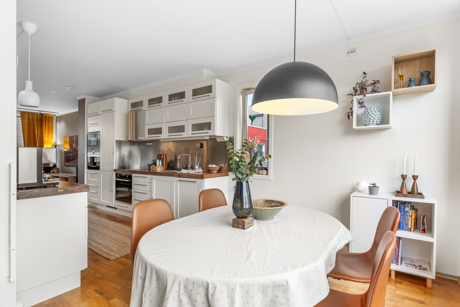 Hvitt og elegant Huseby-kjøkken med integrerte hvitevarer. Mekanisk avtrekk. Spisestuen finner sin naturlige plassering. Galleribilde