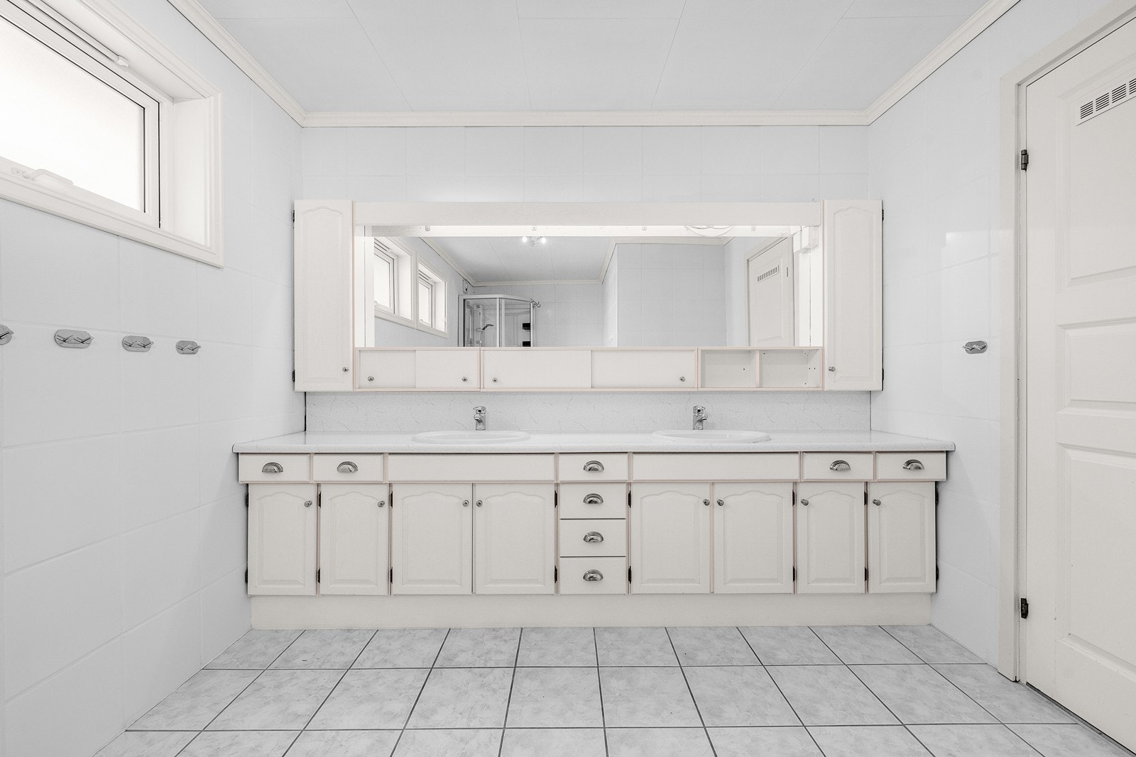 Innredningen består av gulvstående servantskap med profilerte skapdører. benkeplate i laminat og to nedsenkede servanter. Videre er det speil med belysning, vegghengt skap for oppbevaring og stikkontakt over servant Galleribilde