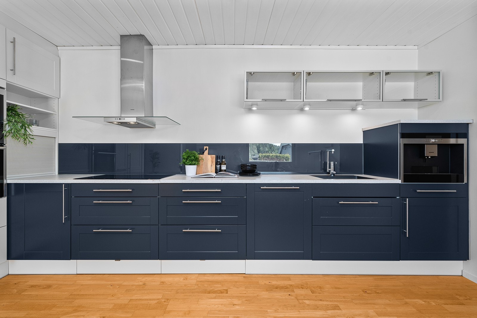 Kjøkkenet er integrert med komfyr og microbølgeovn plassert i høyskap, kaffemaskin, oppvaskmaskin, kjøleskap med frysedel og nedfelt induksjonstopp Galleribilde