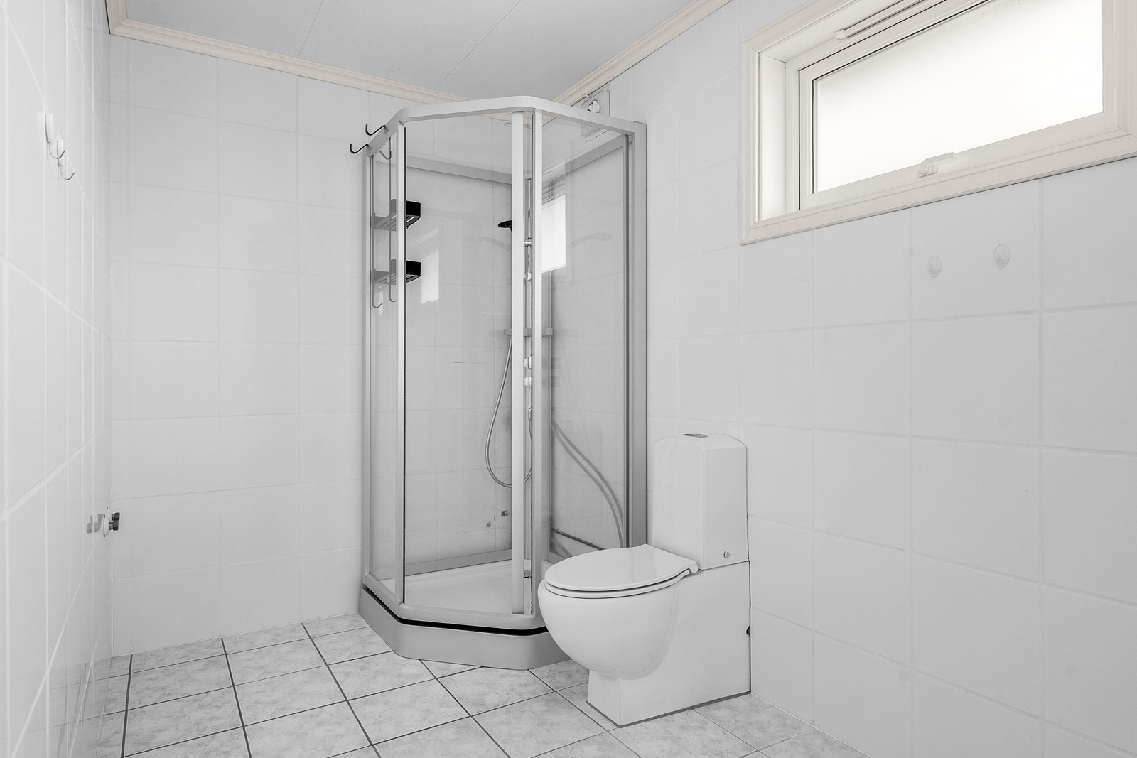 Det ble i 2021 lagt flis-på-flis på vegger, og rommet er innredet med dusjkabinett og frittstående toalett Galleribilde