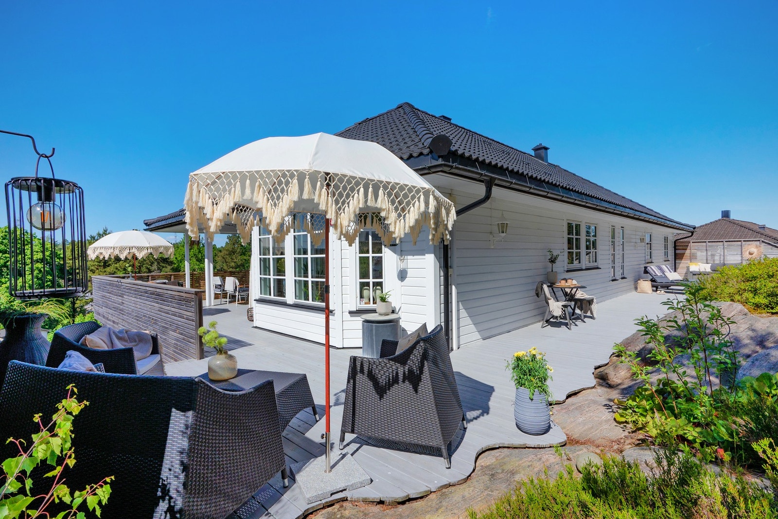 Tomten rundt huset er nydelig opparbeidet med flere uteplasser, gressplen med plass til trampoline og lekeapparater, samt naturlige vekster som blåbærlyng og grøntområder. Galleribilde