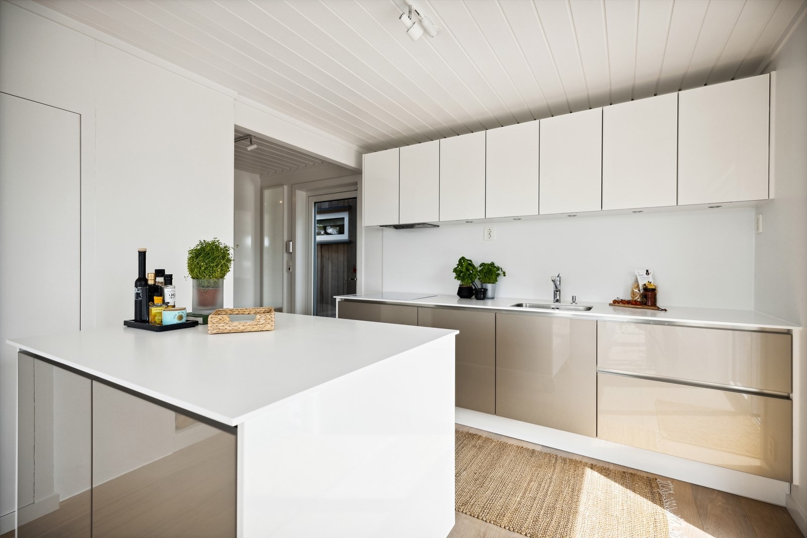 Kjøkkenet har Corian benkeplate og sprutbeskyttelse sømløst sammensveiset. Galleribilde