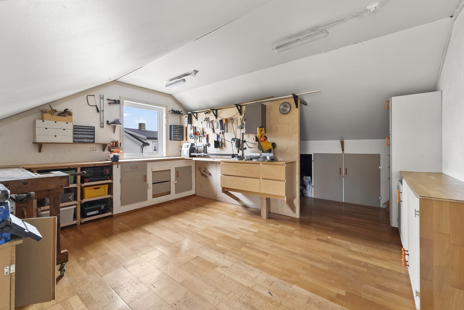 Lyst og romslig hobbyverksted med skråtak, praktisk oppbevaring og god arbeidsplass. Perfekt for kreative prosjekter og håndverksarbeid. Galleribilde