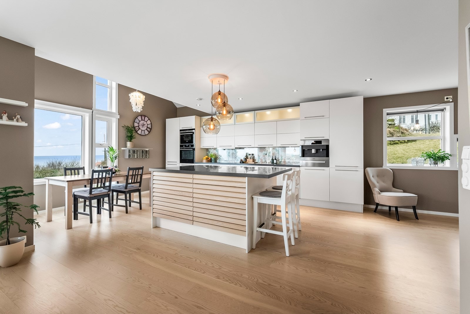 Åpen stue/kjøkkenløsning med nydelig utsikt til havet Galleribilde