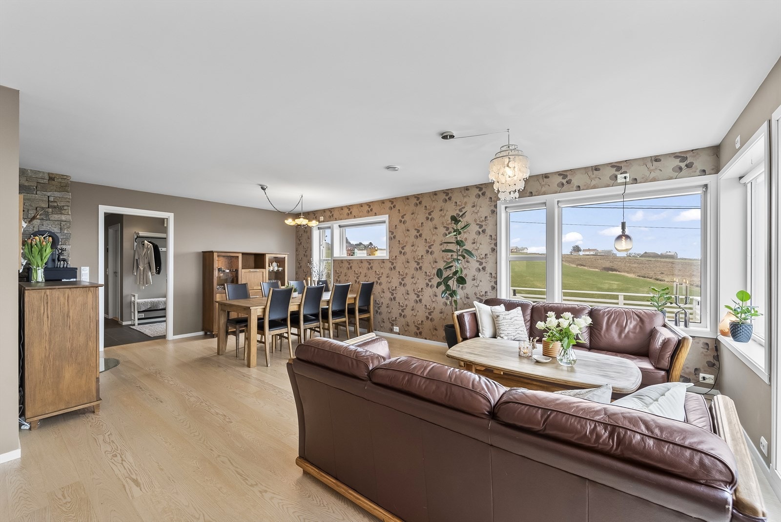 Lys og romslig stue med store vinduer som gir fantastisk utsikt over landlige omgivelser og havet. Perfekt for avslapning og samvær. Galleribilde