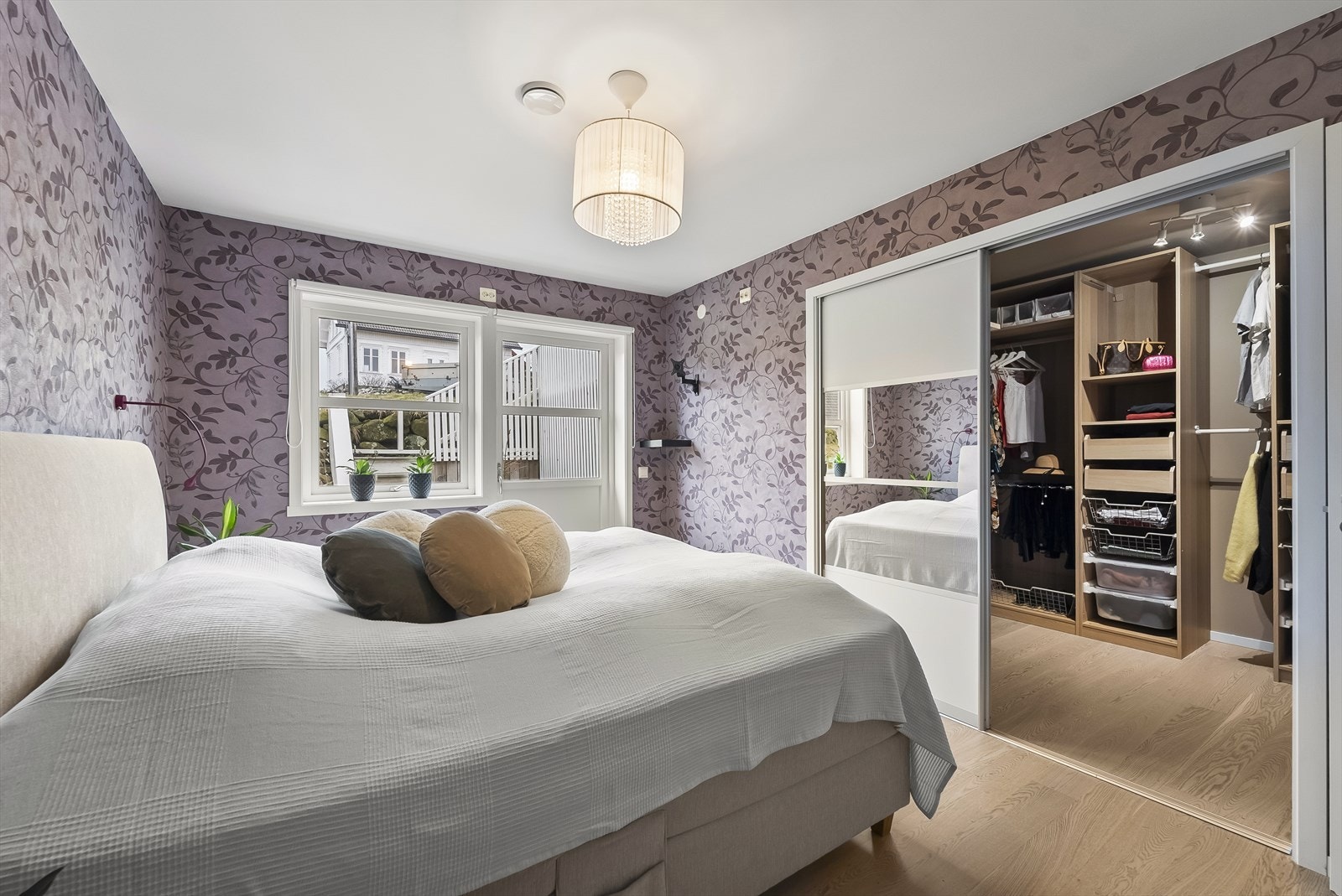 Innbydende hovedsoverom med skyvedører som leder inn til praktisk klesrom Galleribilde