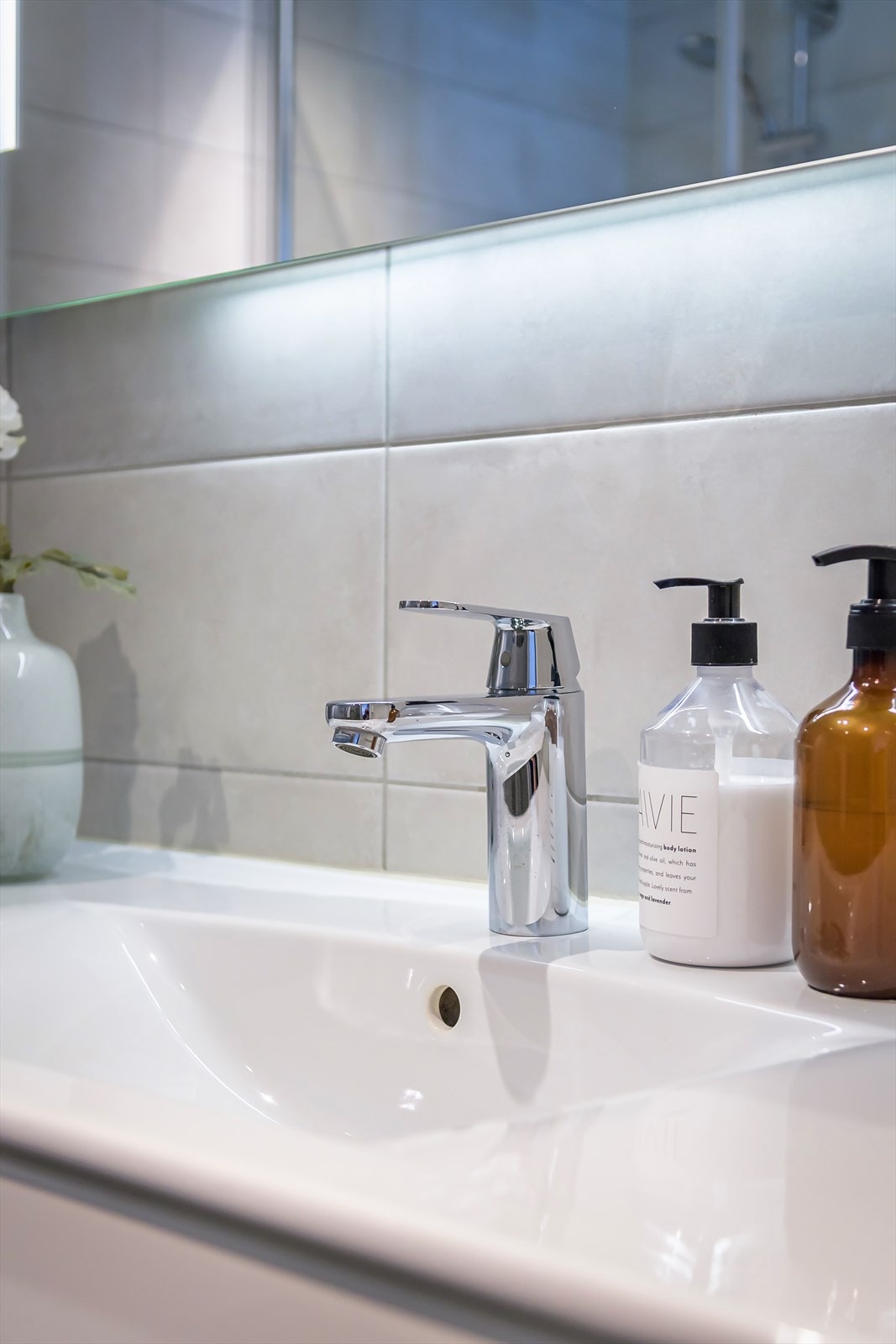 Badet har sanitærutstyr som veggmontert toalett, dusjnisje, servant og opplegg til vaskemaskin og tørketrommel. Galleribilde