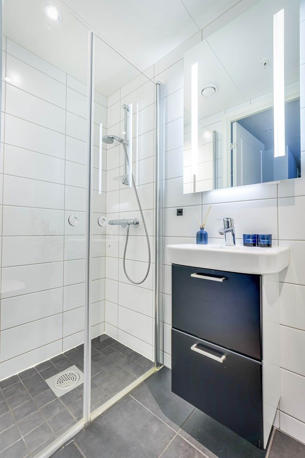 Bad med tilkomst fra entré. Det er varmekabler i gulv og spotter i tak. Det er avtrekk til balansert ventilasjon og luftespalte i dør. Galleribilde