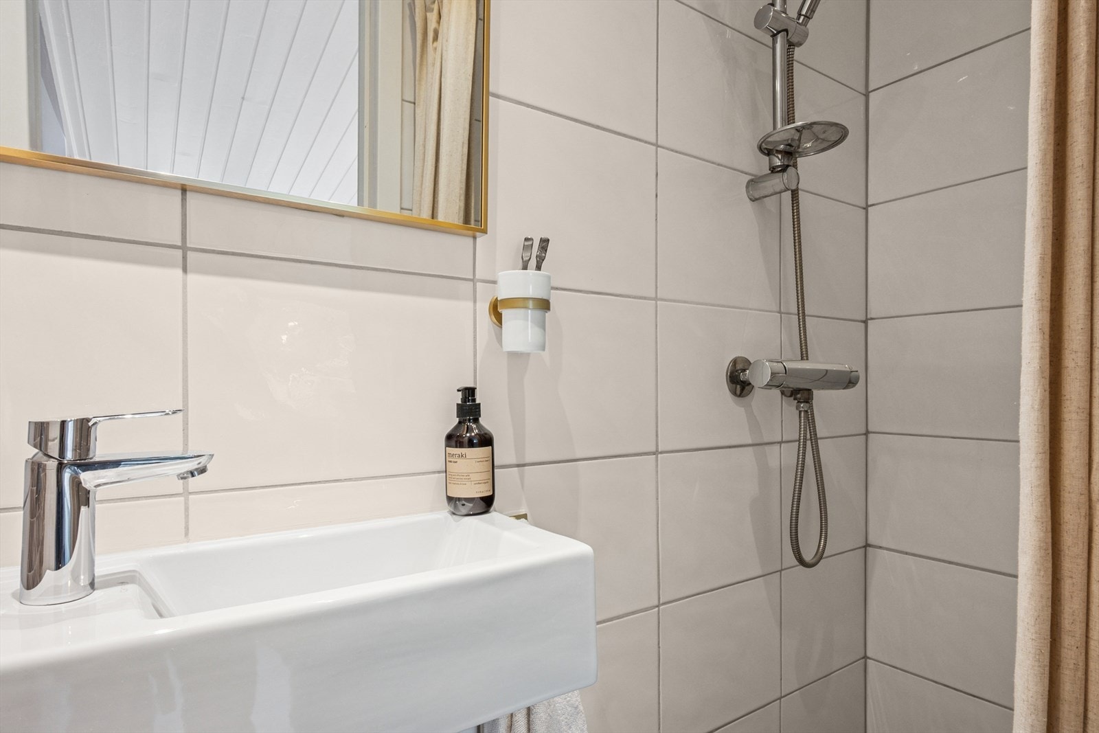 Innredning med servant, veggfestet toalett og dusjhjørne. Galleribilde