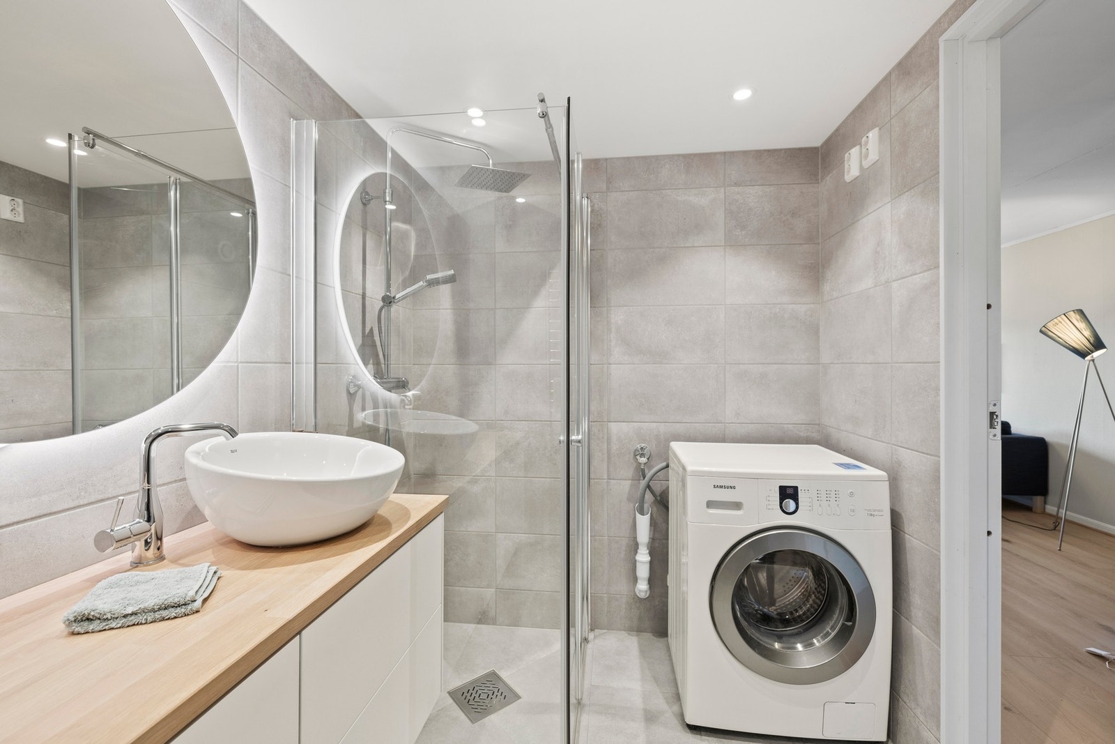 Badet har flotte grå fliser på både gulv og vegger, og fremstår som moderne og stilrent. Galleribilde