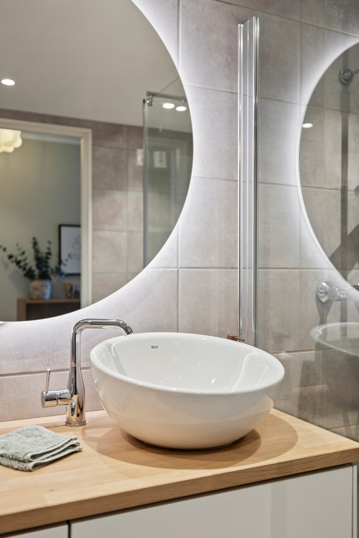 Elegant bolleservant og speil med belysning gir badet et moderne preg. Galleribilde