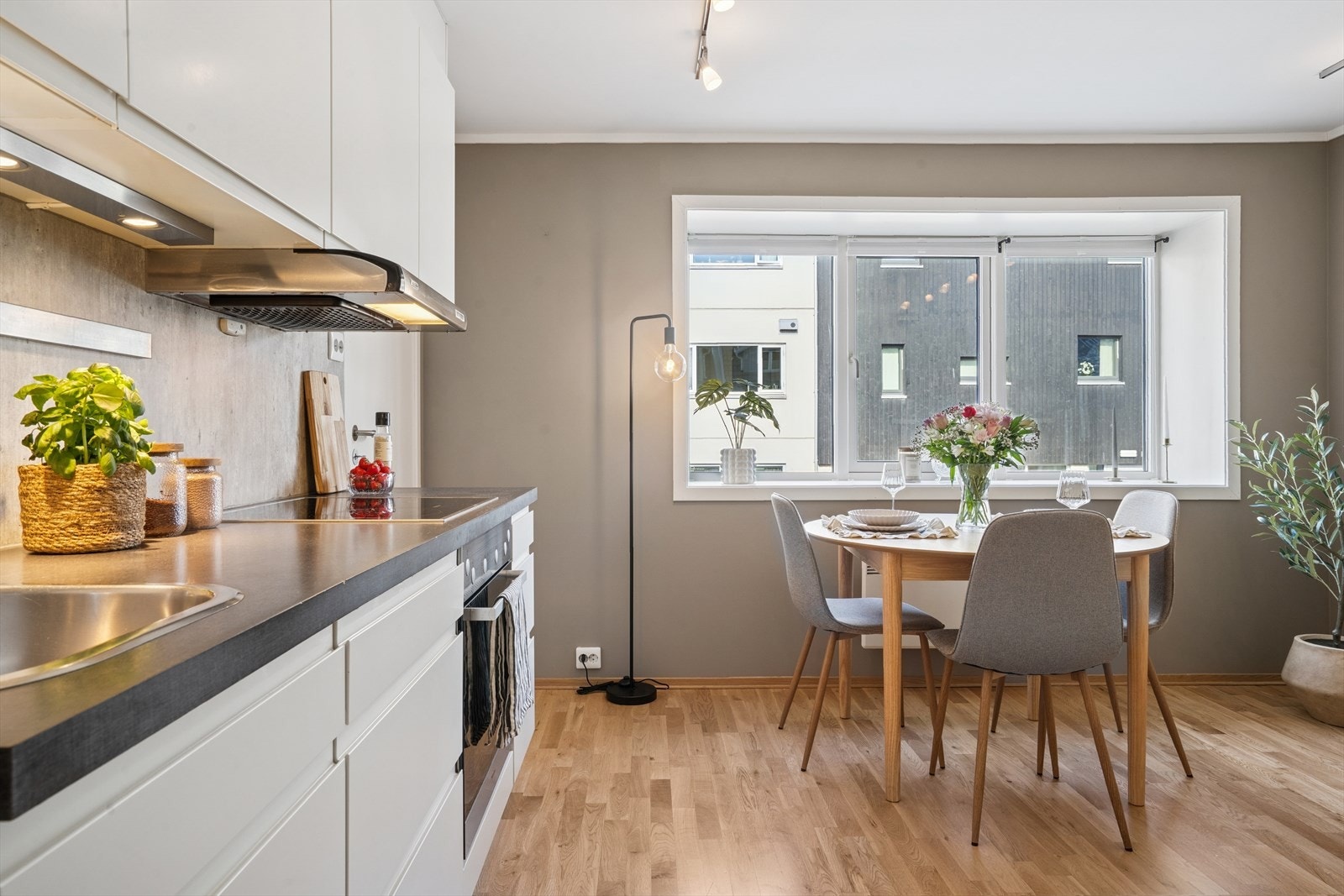 Innredningen har hvite slette fronter med integrerte gripelister og en pen grå laminatbenkeplate. Galleribilde