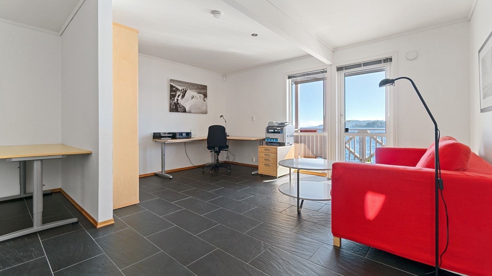 Kontordelen har eget ildsted og flislagt gulv. Det er verandadør til romslig balkong mot syd, med nydelig sjøutsikt! Galleribilde