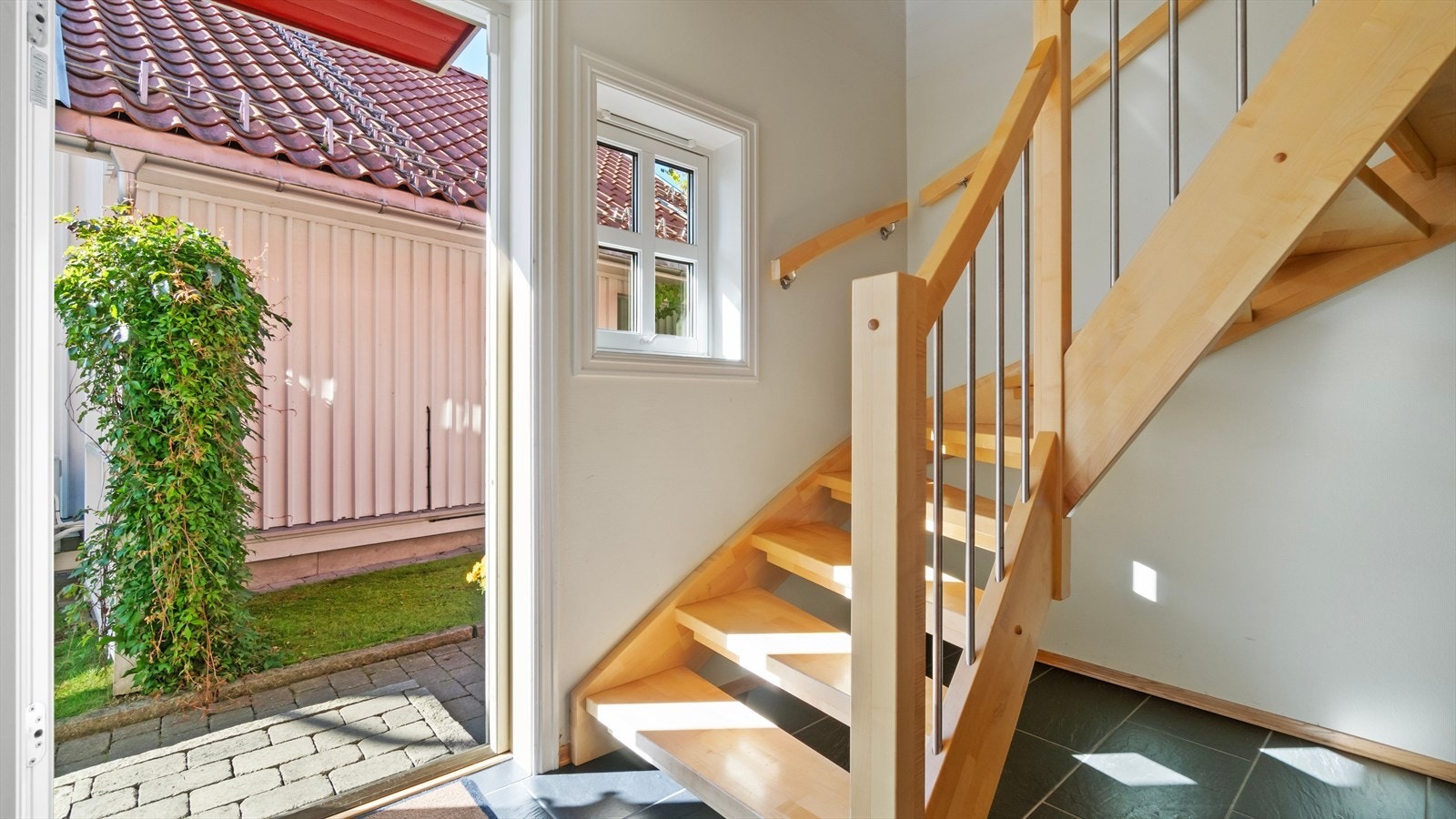 Fin og romslig entré i 1. etasje, med flislagt gulv og to doble garderobeskap for oppbevaring av sko- og yttertøy. Galleribilde