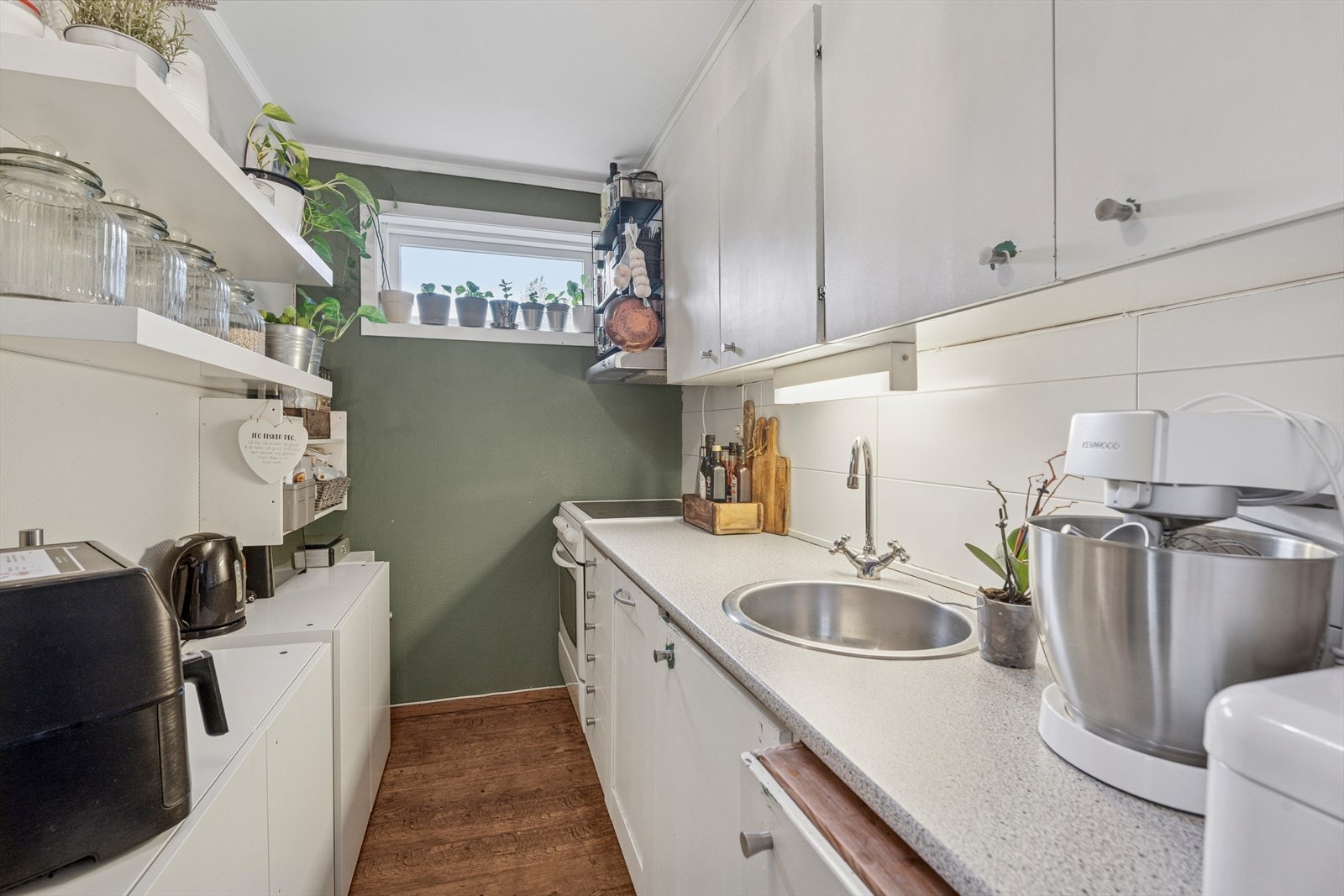 Hybelen har en åpen kjøkkenløsning av ukjent alder. Kjøkkenet har en innredning med glatte fronter, benkeplate av laminat, fliser over benk og opplegg for oppvaskmaskin. Galleribilde