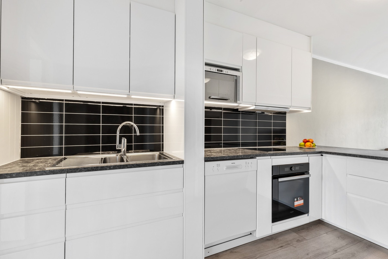 De hvite, glatte frontene og den slitesterke laminatbenkeplaten med integrert vask gir et lyst og elegant uttrykk. Galleribilde