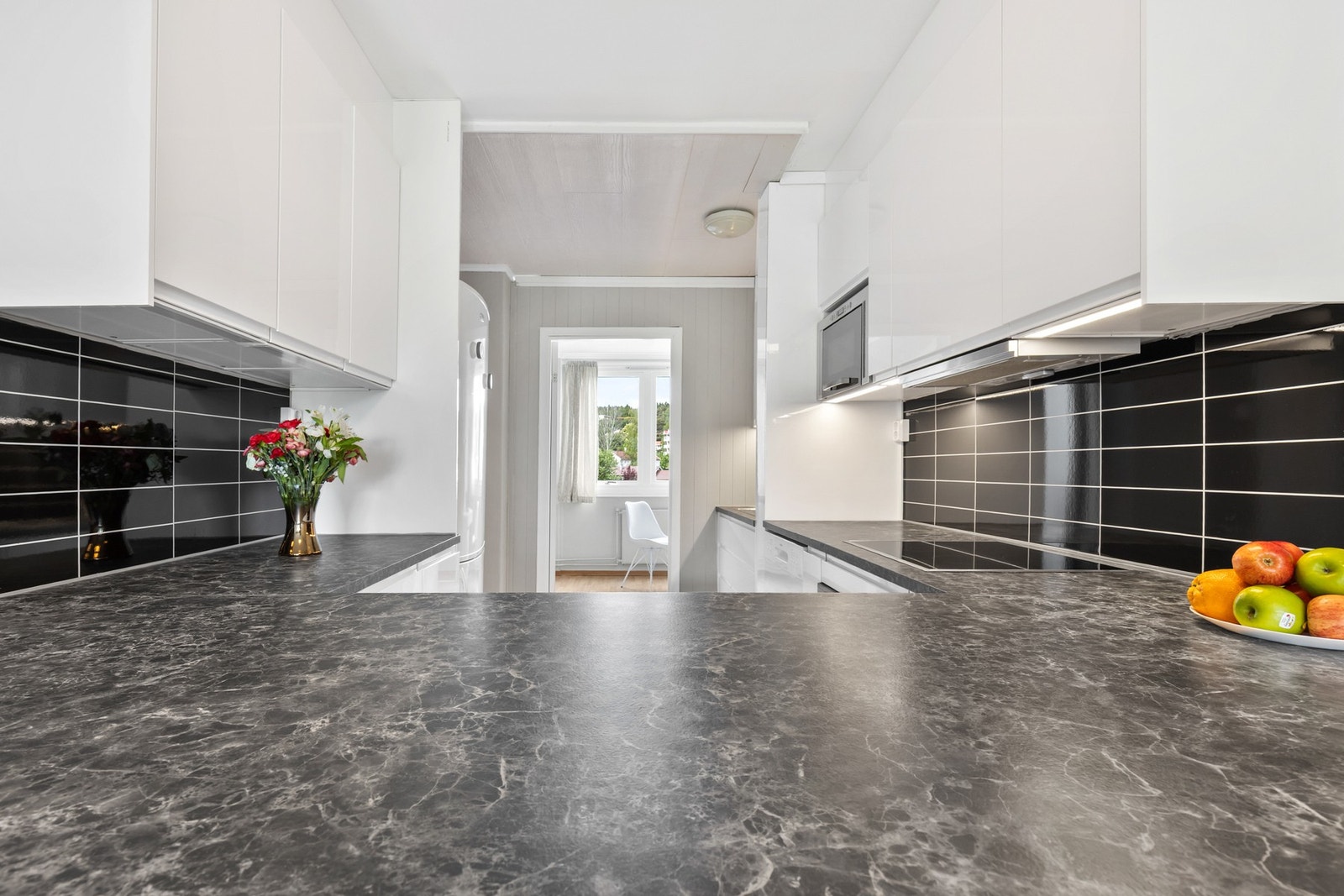 En delvis åpen løsning mellom kjøkken og stue skaper en lys og luftig atmosfære som innbyr til sosialt samvær og god flyt i hverdagen. Galleribilde