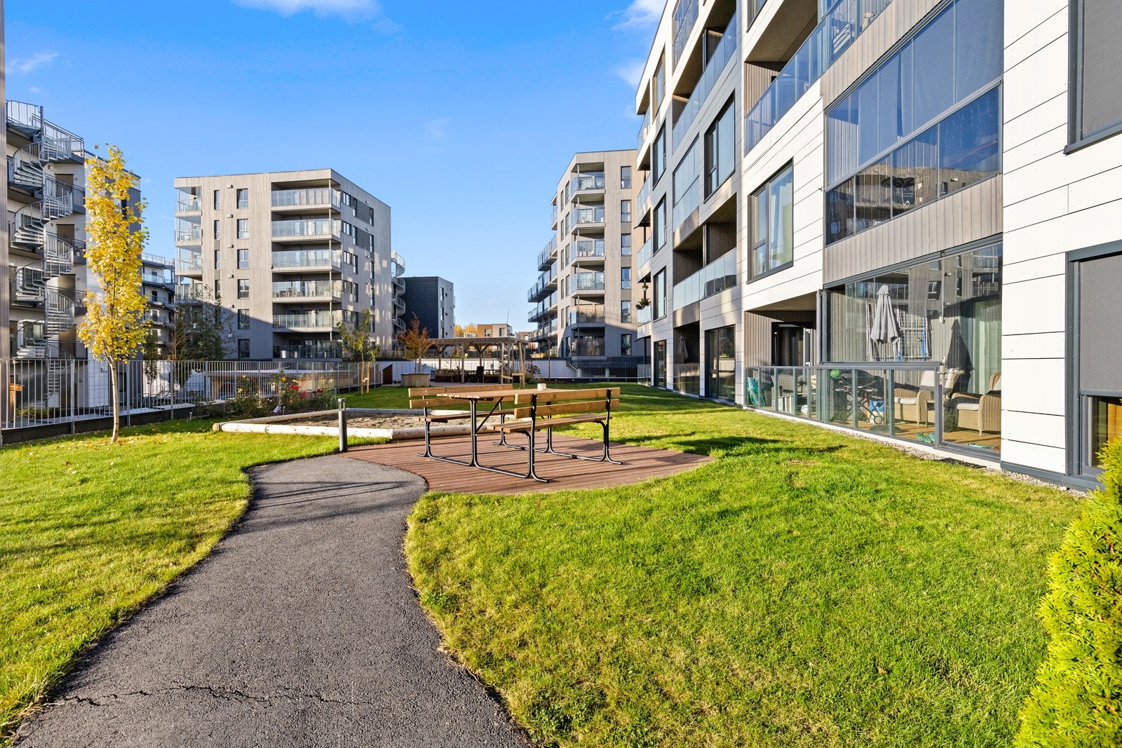 Fine fellesarealer med grønne uteområder, beplantninger, trær, sittegrupper m.m. Galleribilde