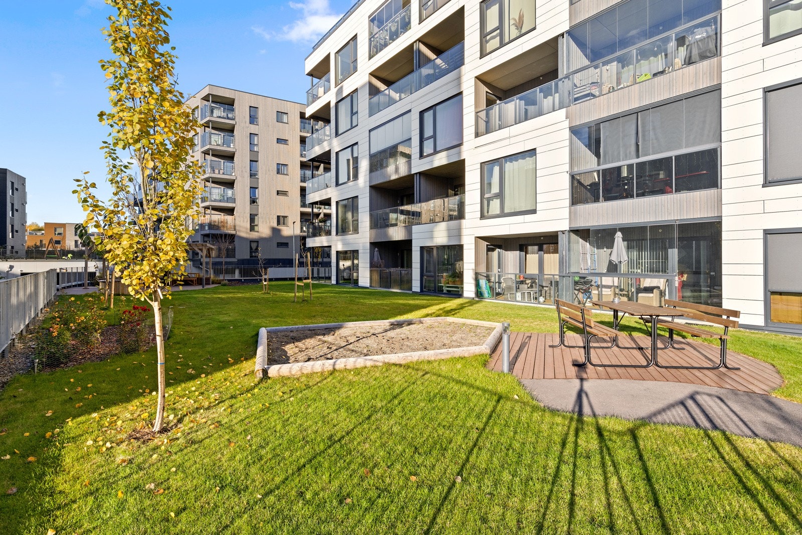 Fine fellesarealer med grønne uteområder, beplantninger, trær, sittegrupper m.m. Galleribilde