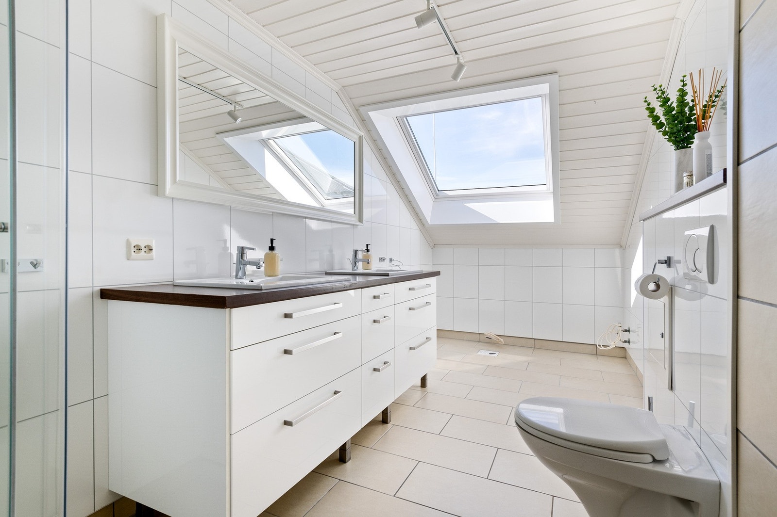 Badet er fra 2010 og har fliser på gulvet med lun gulvvarme. Veggene har en kombinasjon av fliser og flissplater. Innredningen består av en mørk benk med to nedfelte servanter og hvite underskuffer. I tillegg har badet dusjkabinett og veggmontert toalett, Galleribilde