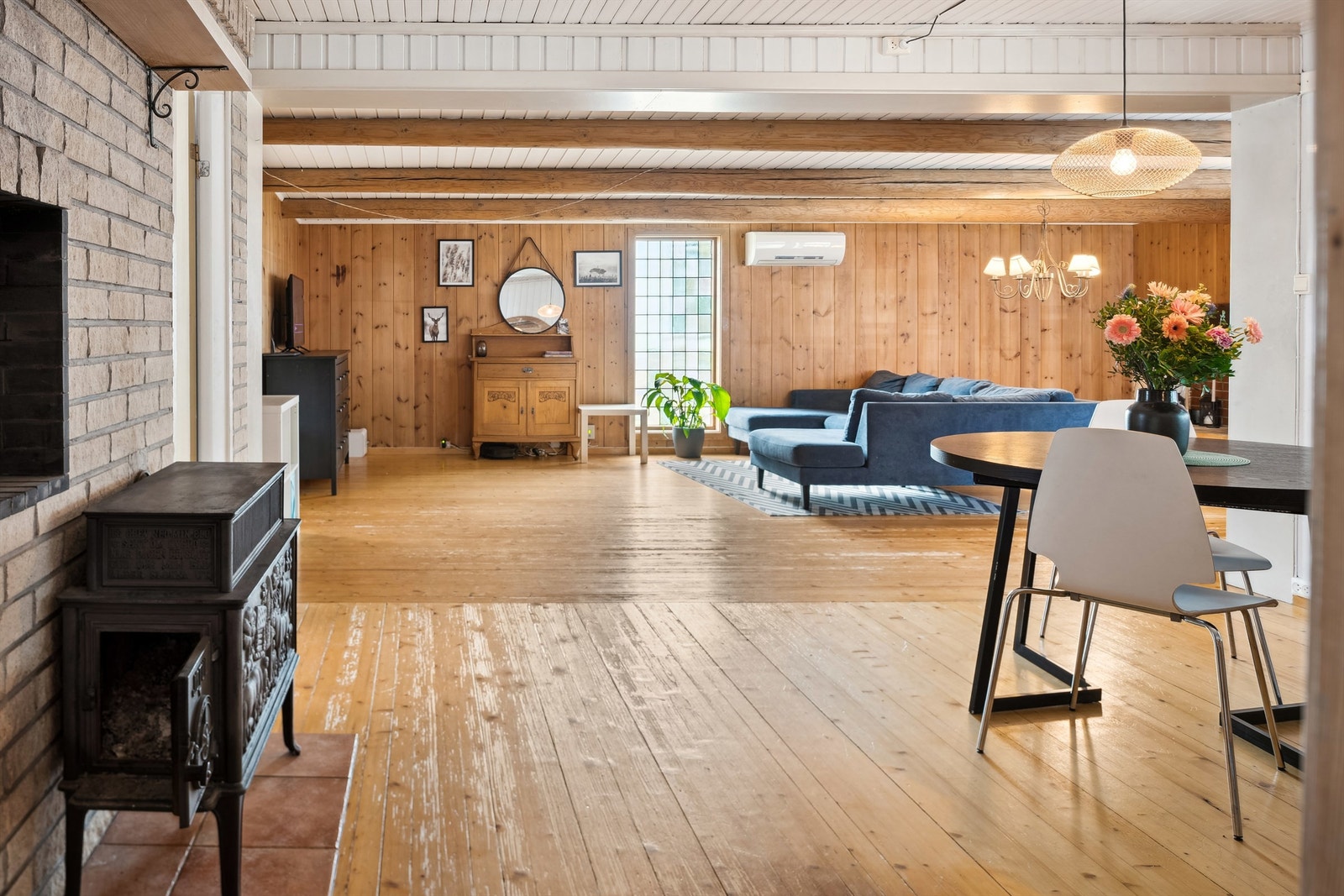 Fra kjøkkenet kommer man ut til stuen/spisestuen. Spisestuedelen har hvitmalt panel på veggene og i himling og furugulv. Galleribilde