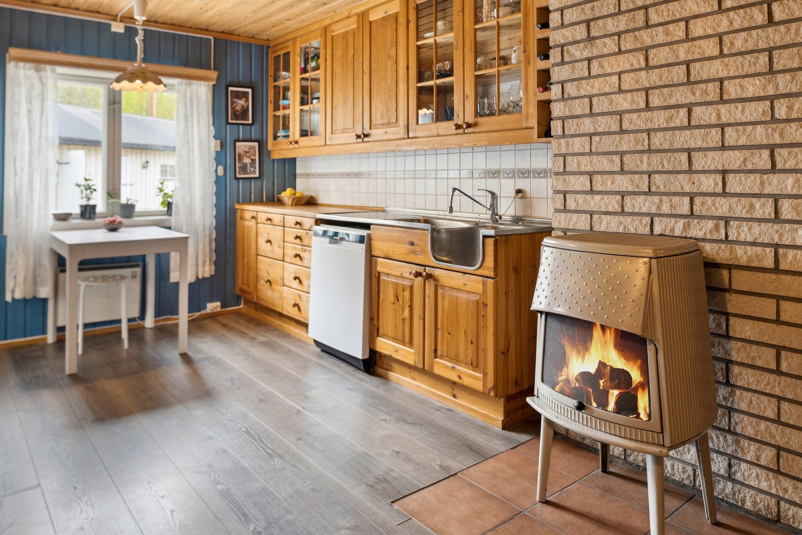 Vedovn montert på fliser på gulvet. Denne og panelovnene er varmekilder i rommet. Galleribilde