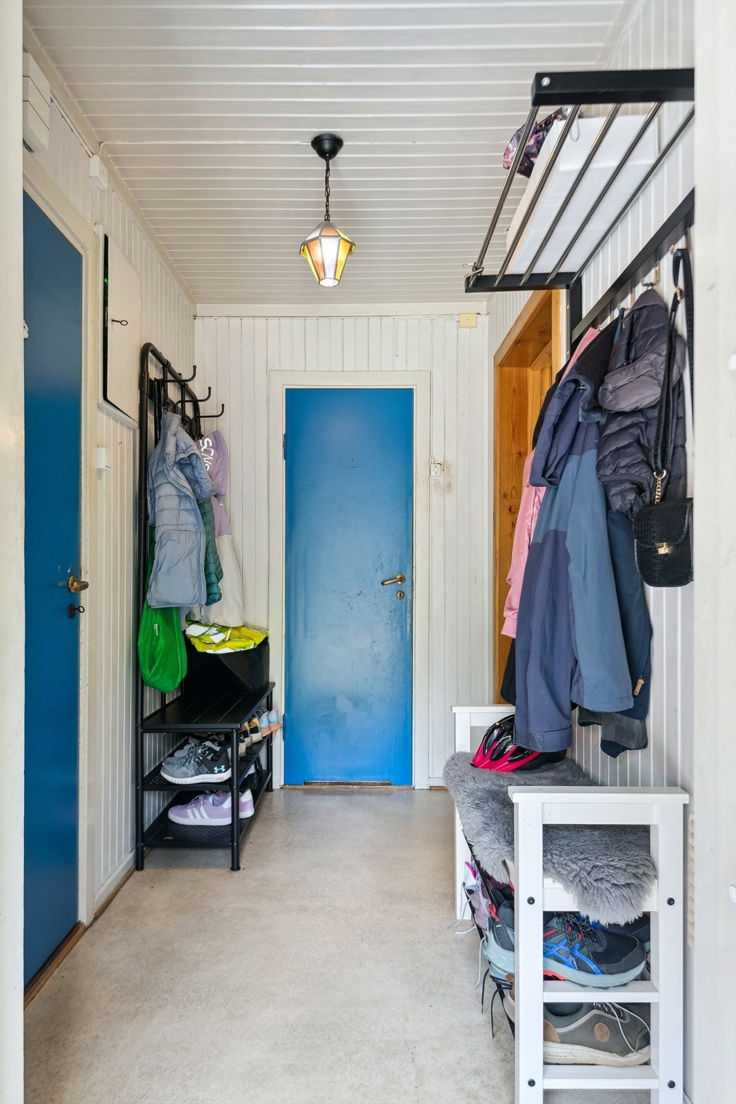 Inn den grønne inngangsdøren kommer man inn i en lys entré med lyst belegg på gulvet og hvitmalt panel på veggene. Galleribilde