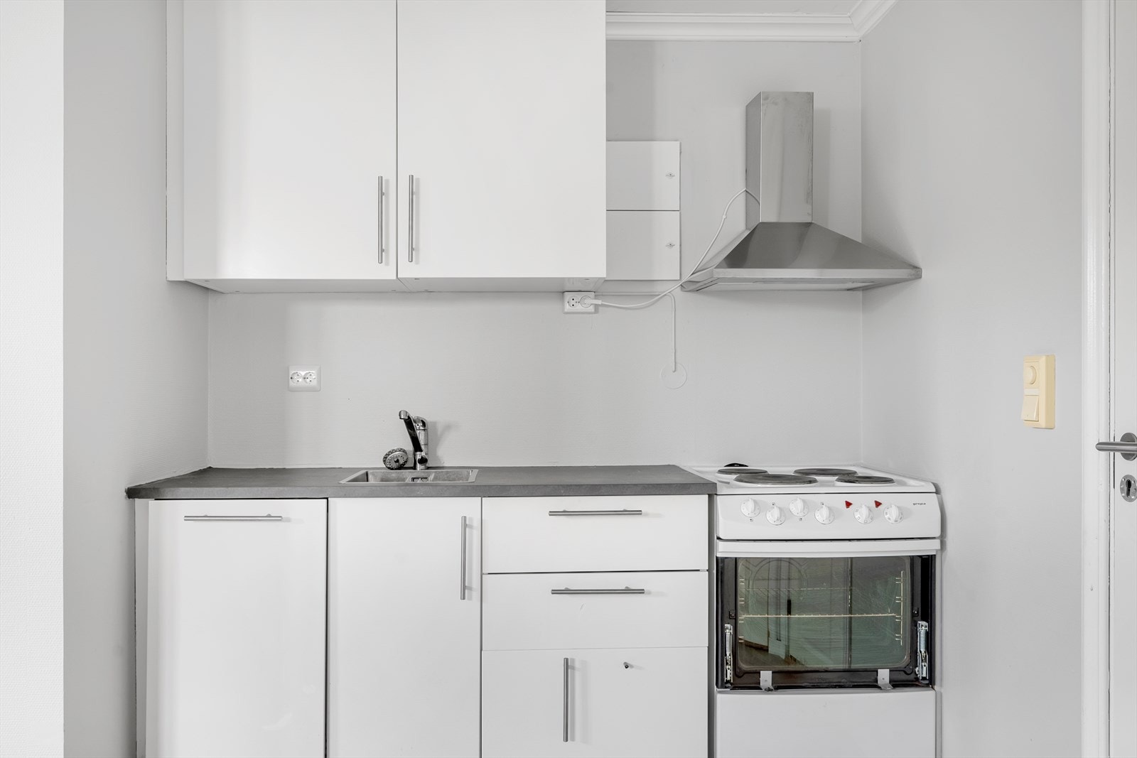 Kjøkkeninnredningen fra 2022 har det man trenger funksjonelt plassert på én vegg, utstyrt med integrert oppvaskmaskin og ventilator med kullfilter. Galleribilde