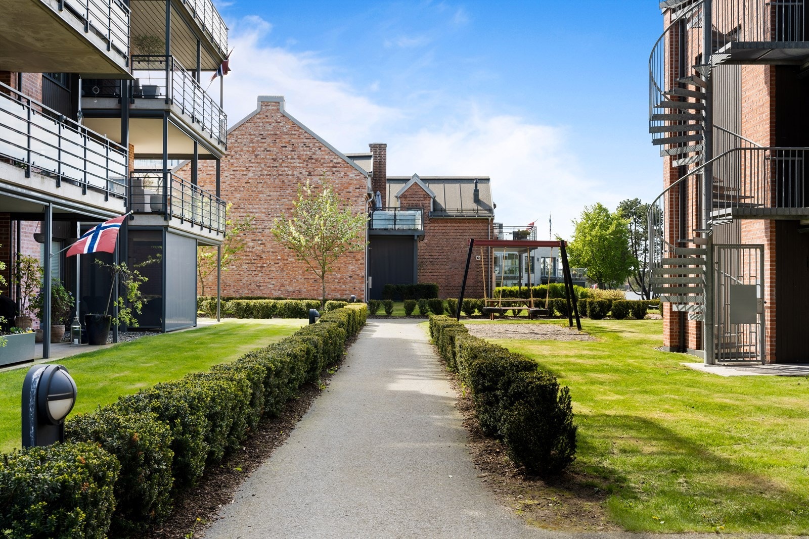 Sameiets tomt er pent opparbeidet med grøntarealer, diverse beplantning, lekeplass og felles sittegrupper Galleribilde