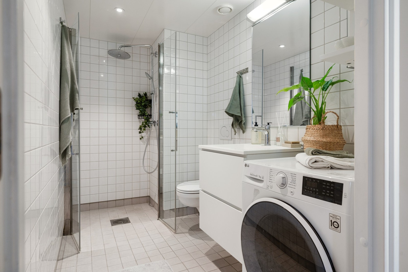 Baderommet har vegghengt toalett, dusjhjørne og opplegg for vaskemaskin. Galleribilde