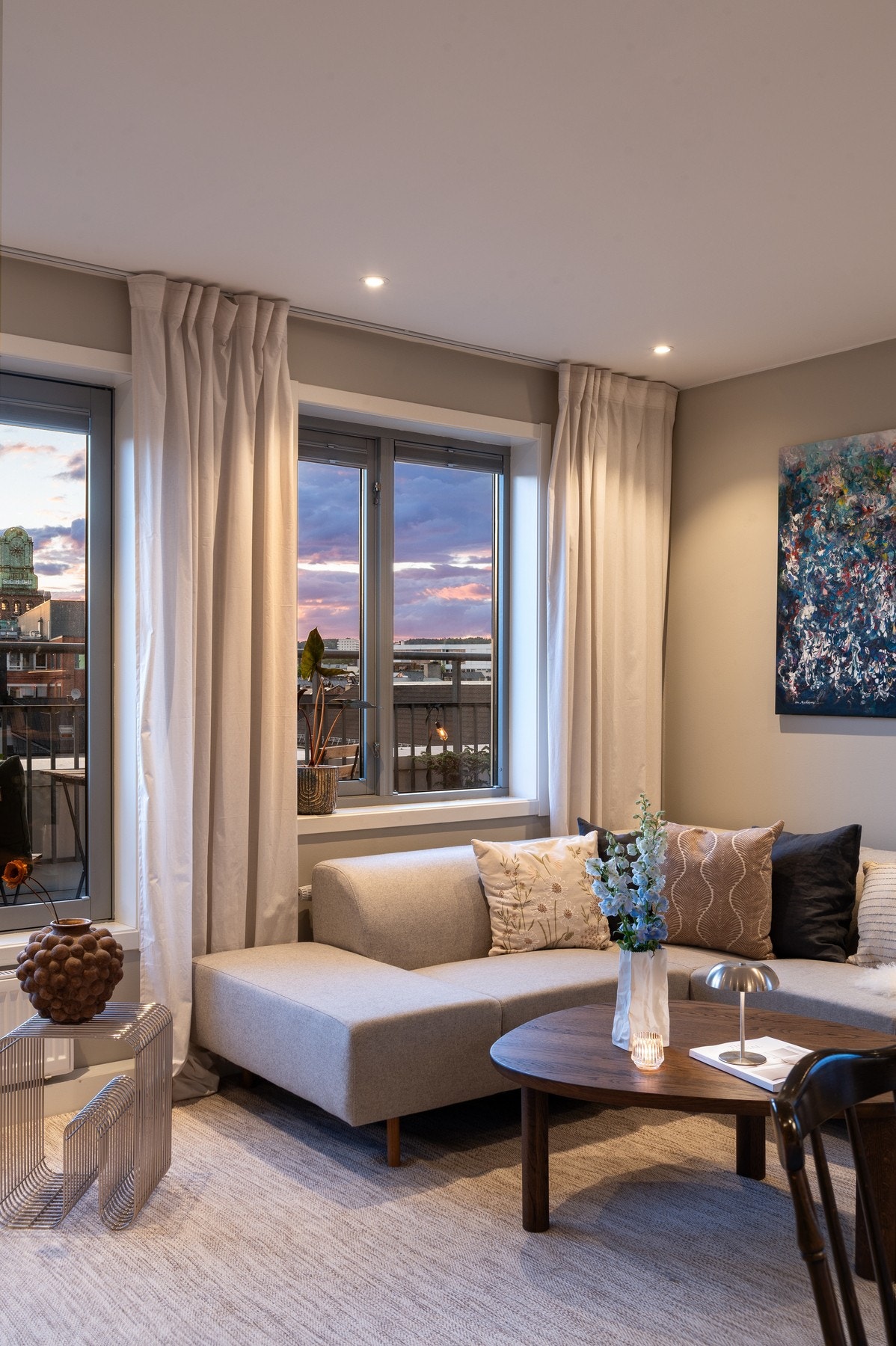 Stuen har store vinduer, lys innredning og flott utsikt mot byen. Galleribilde