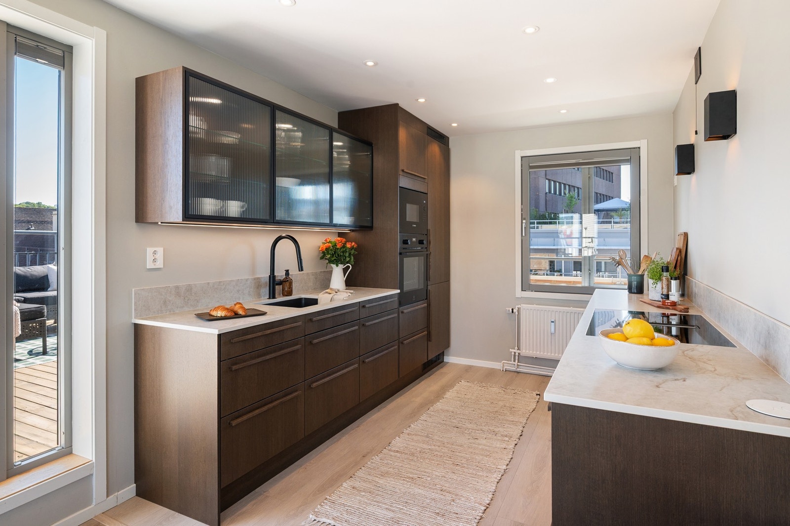 Det har glatte skapfronter og keramikk benkeplater, som gir praktiske arbeidsflater. Galleribilde