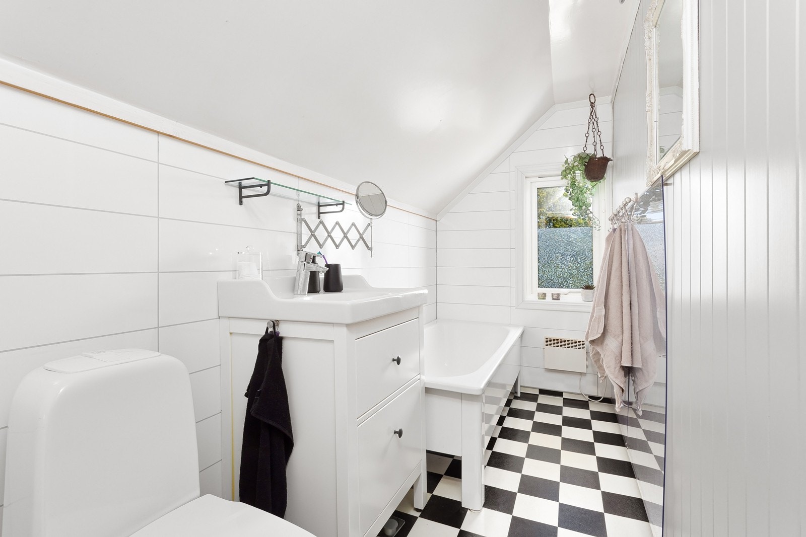 Lyst bad som er innredet med servant, badekar og toalett. Galleribilde
