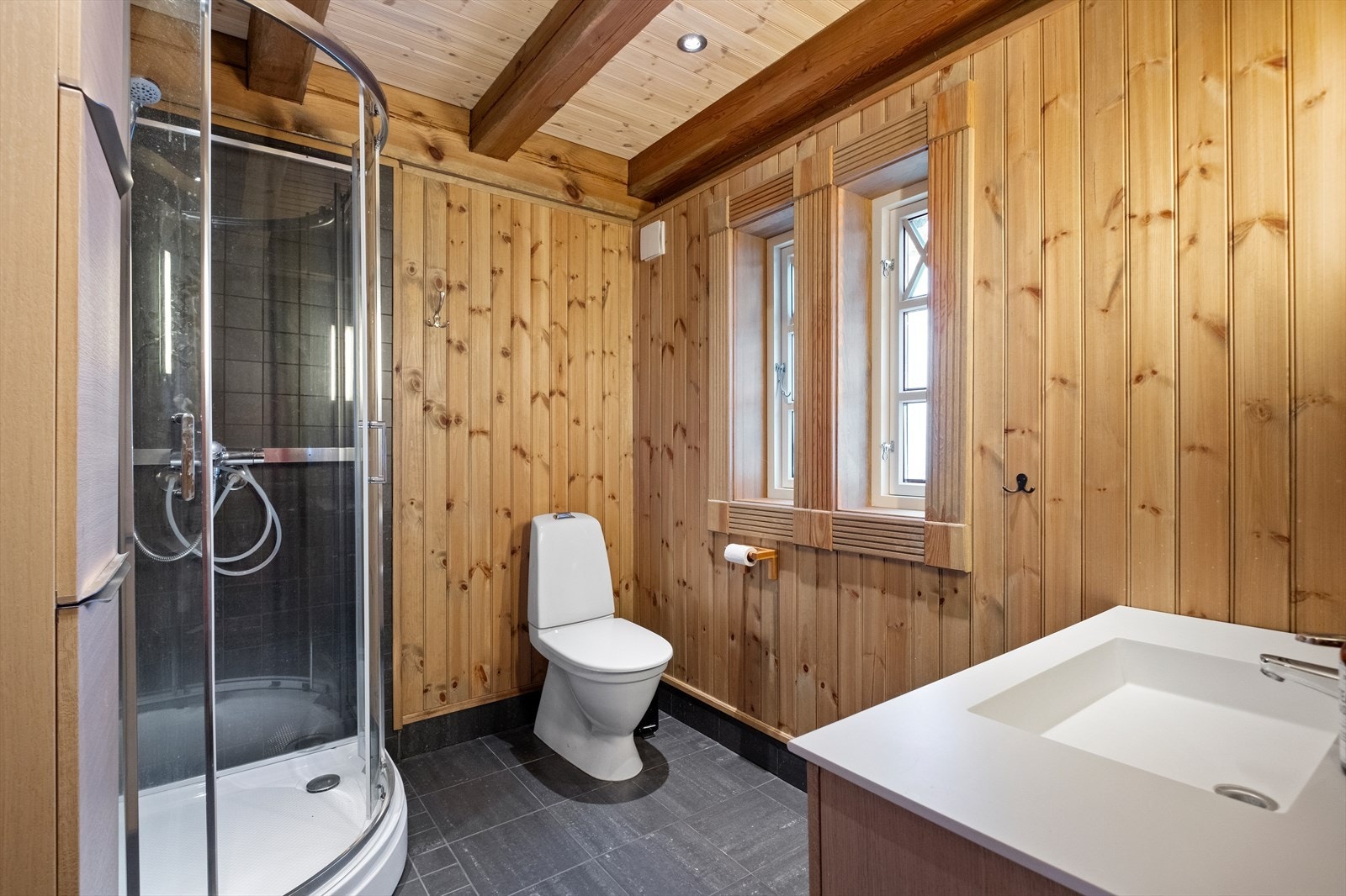 Badet har flislagt gulv og dusj sone Galleribilde