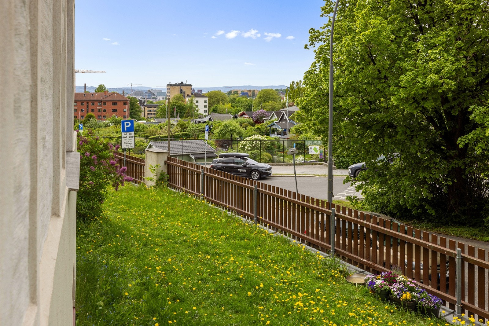 Utenfor stue- og kjøkkenvinduene har man en hyggelig forhage som i disse dager er i full blomst. I bakgrunnen ser man idylliske Rodeløkken kolonihager. Galleribilde